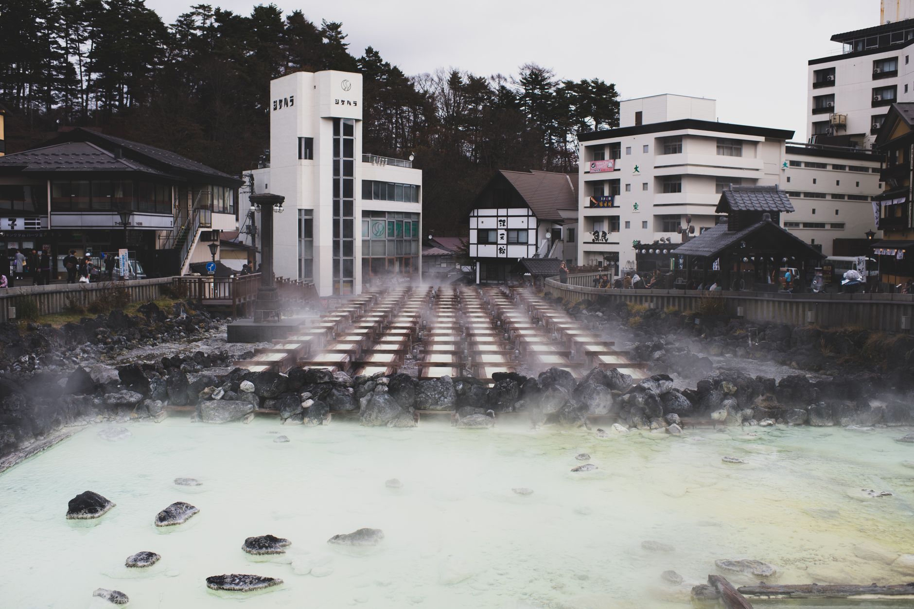 An open-air natural hot spring bath surrounded by mountain scenery