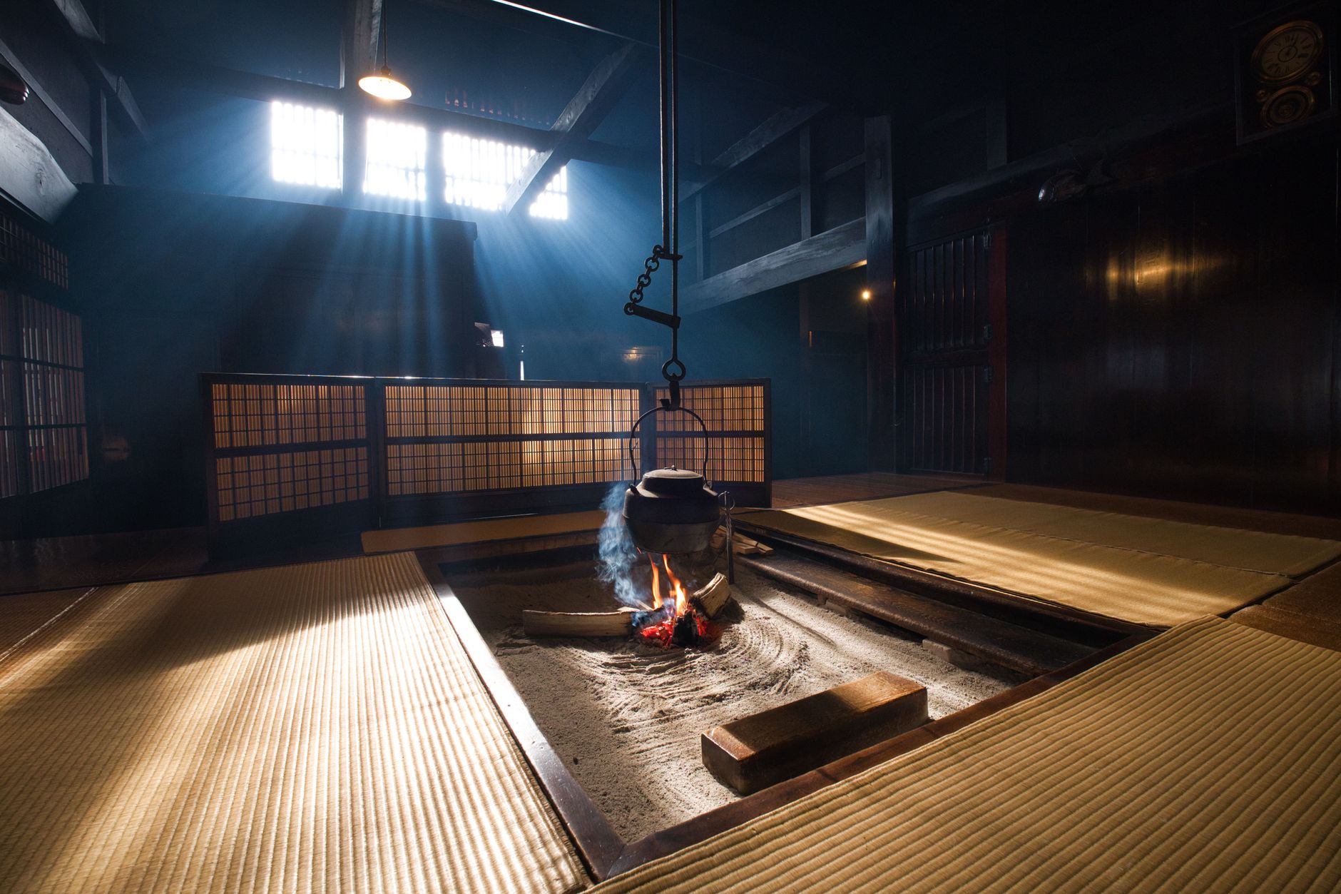 A traditional Japanese tatami room with a sunken hearth, reflecting traditional ryokan-style architecture
