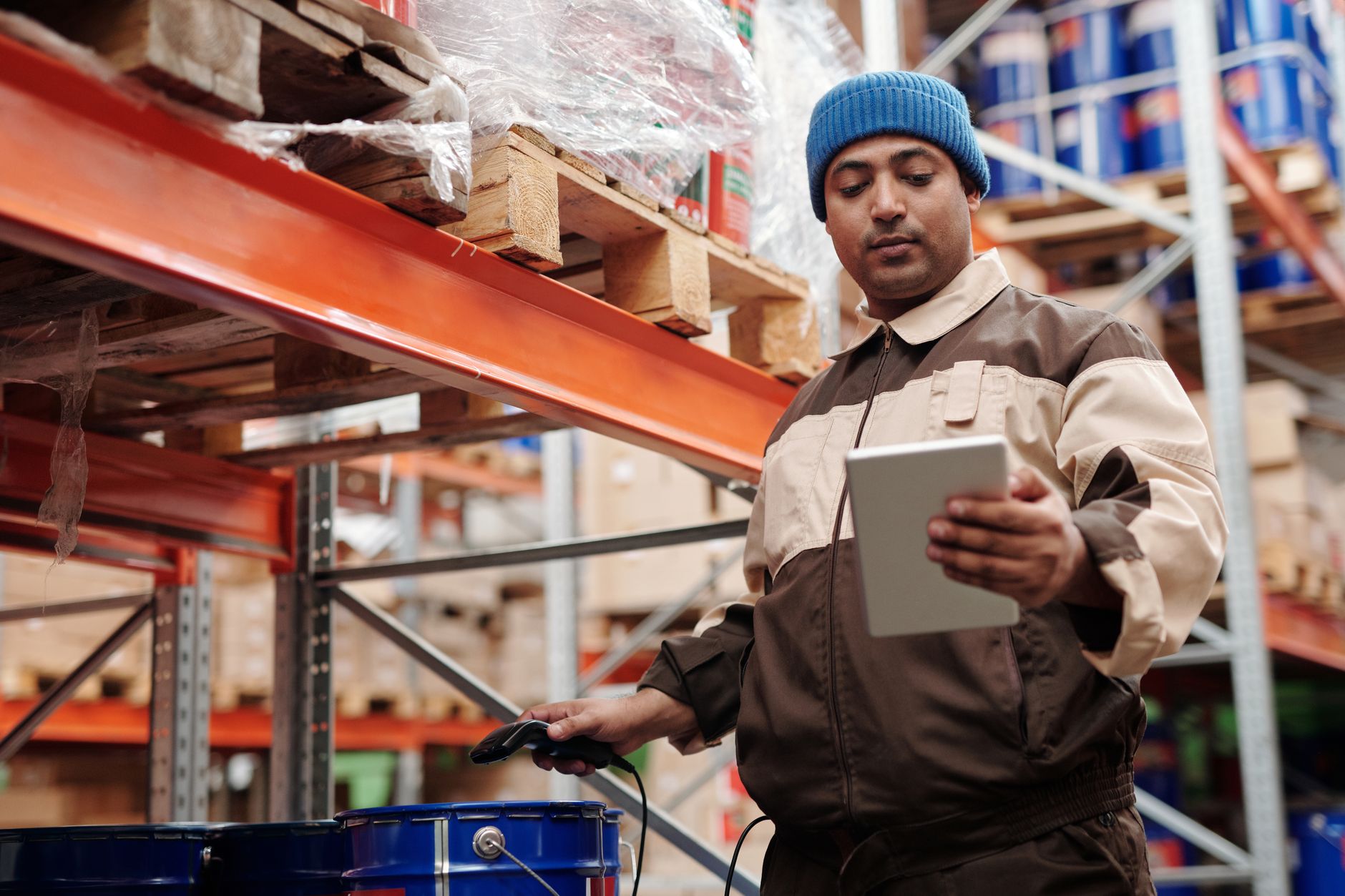 A small business owner checking inventory levels on a tablet in a stockroom