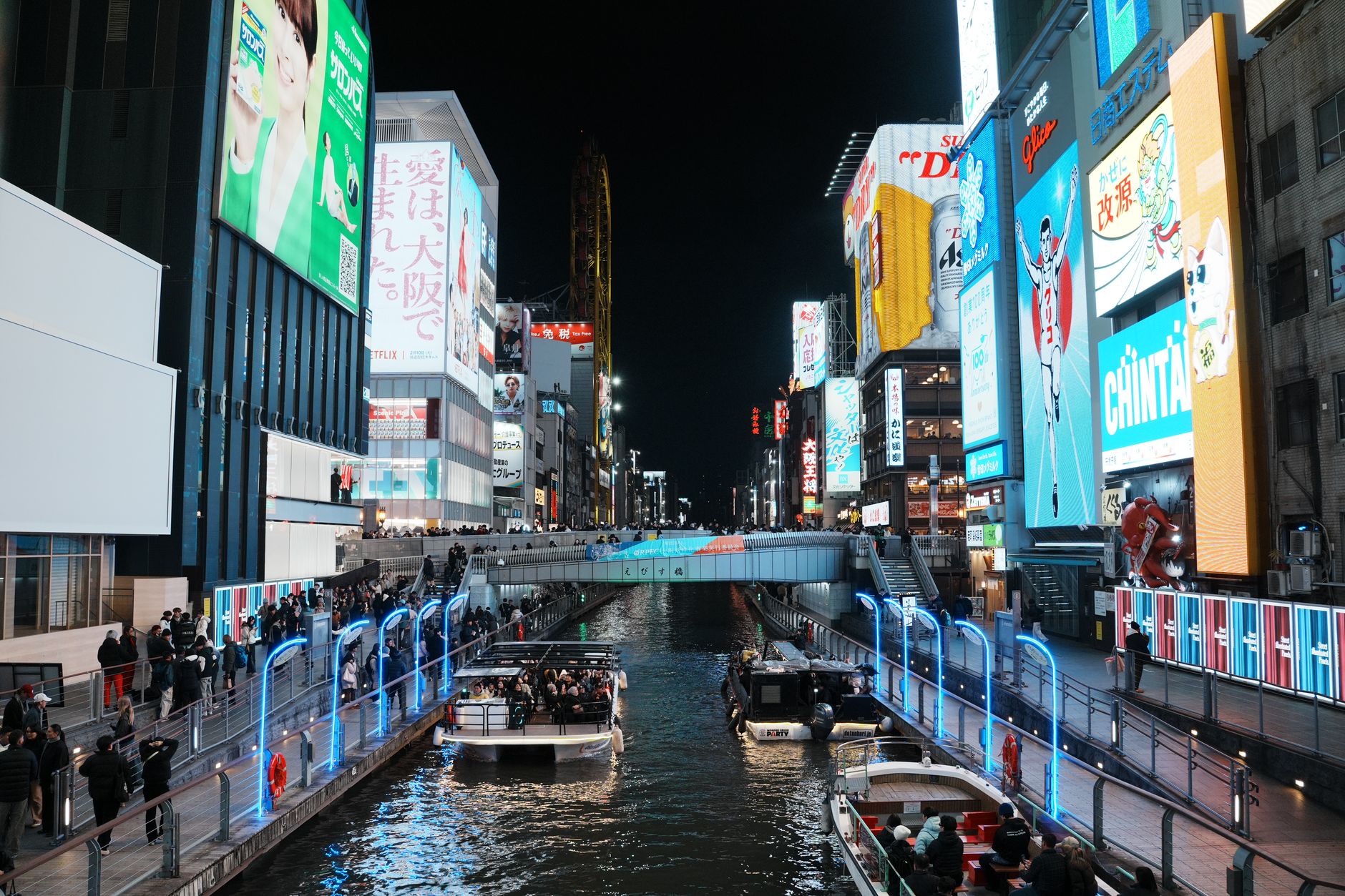 The Dotonbori canal in Namba at night, lined with neon billboards and crossed by Ebisu Bridge
