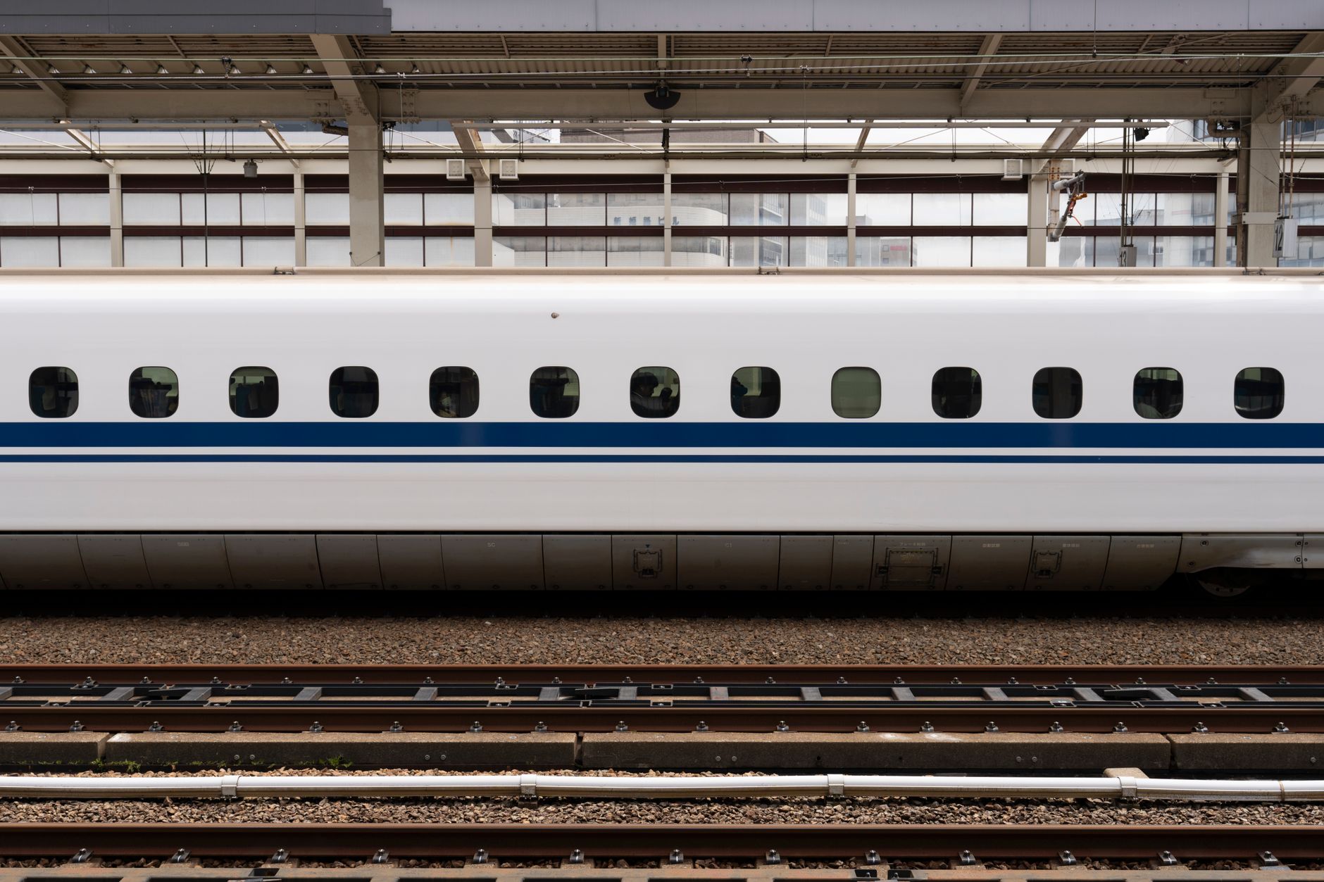 A white and blue Tokaido Shinkansen carriage standing at a station platform
