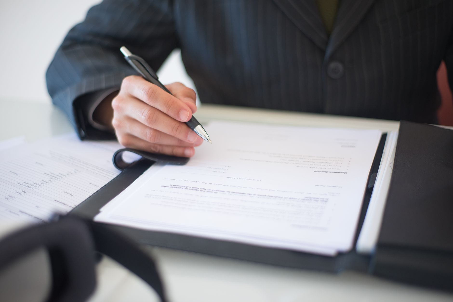 Close-up of a hand signing a business contract document