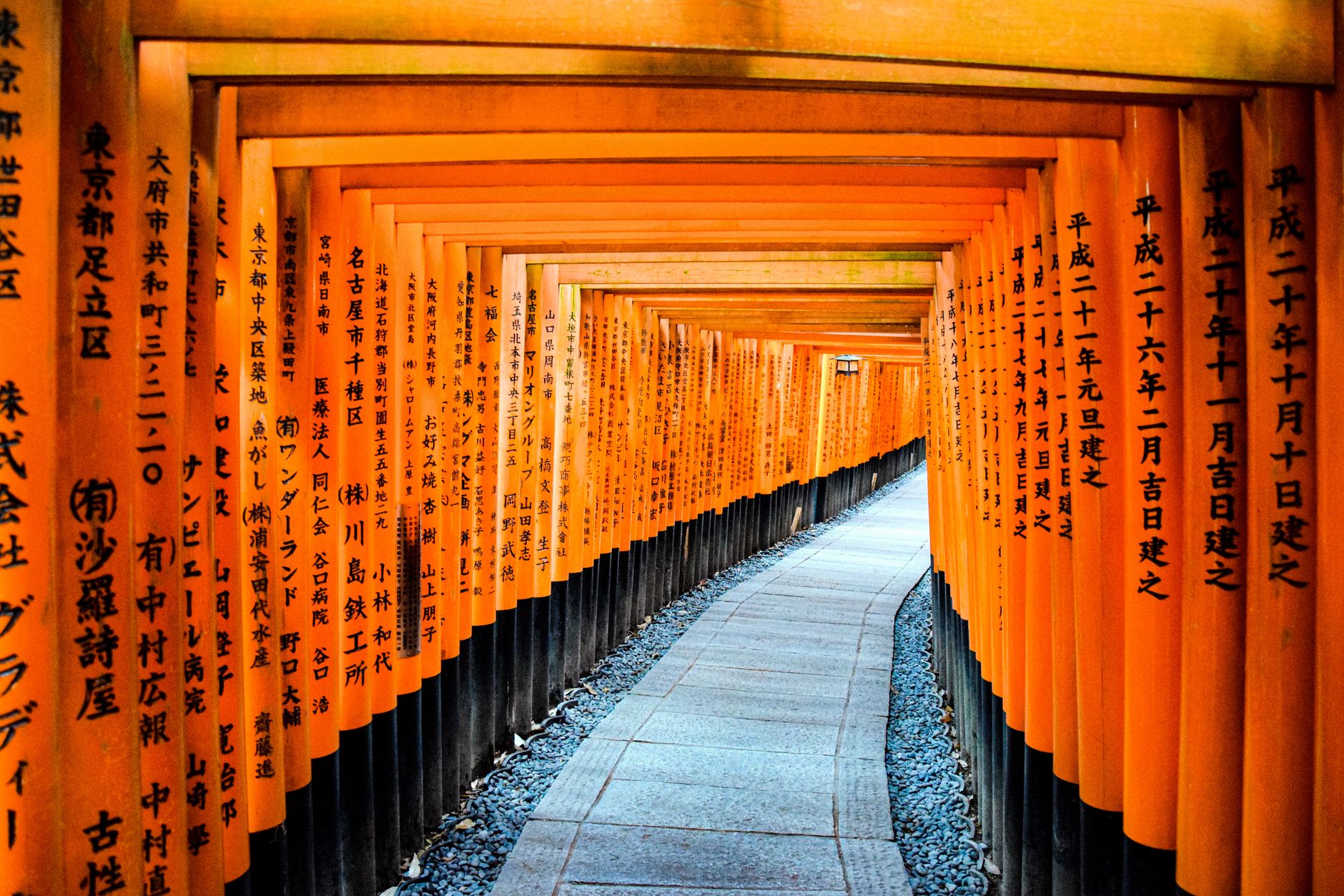 Rows of vermilion torii gates along a stone path at Fushimi Inari Shrine in Kyoto