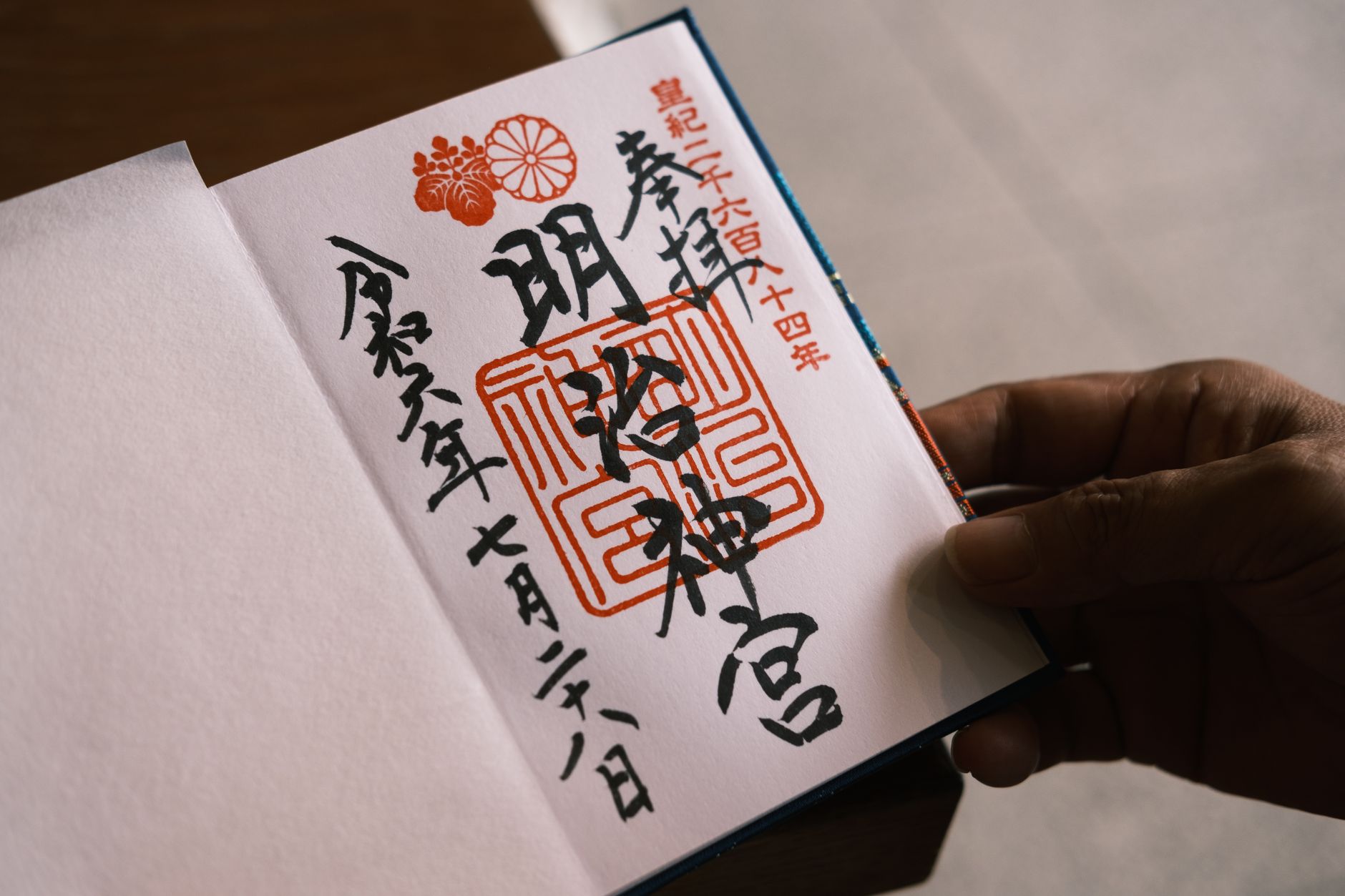Hand stamping a Japanese hanko seal onto a document with red ink