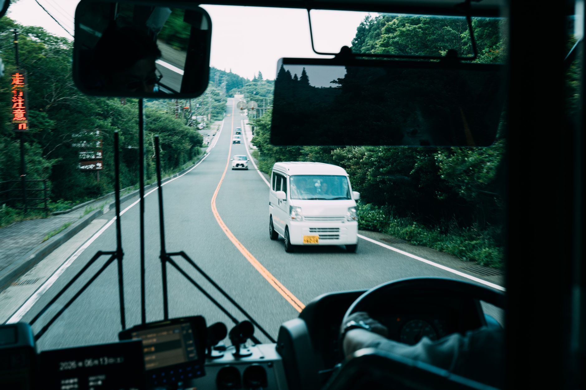 View from the front of a bus traveling on a road in Japan