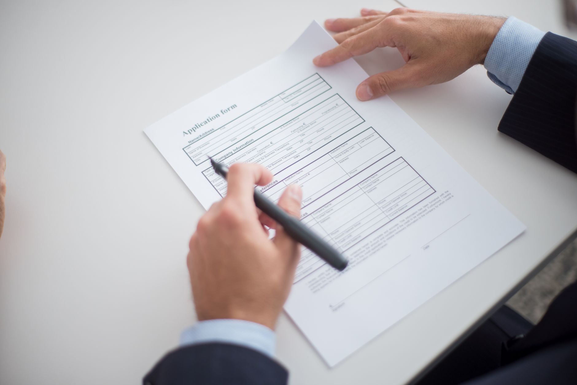 A business professional reviewing an employment document at a desk, representing the checks made before a Certificate of Employment is issued in Japan